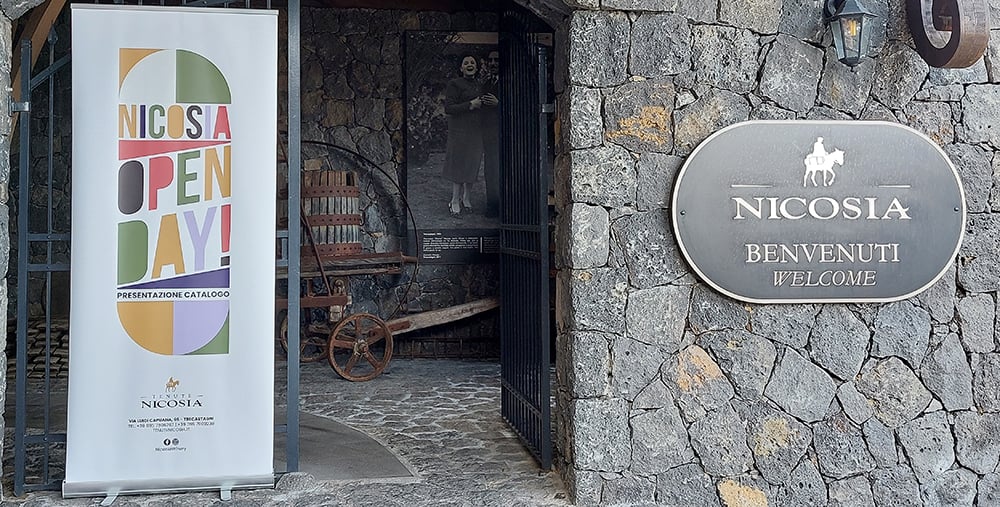 Ingresso di Tenute Nicosia durante l’Open Day 2025, con banner di presentazione del nuovo catalogo e accoglienza per clienti e operatori del settore vitivinicolo.