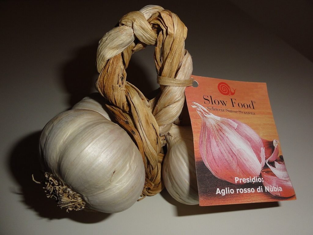 Aglio rosso di Nubia intrecciato a mano, presidio Slow Food della Sicilia occidentale, simbolo della tradizione agricola trapanese.