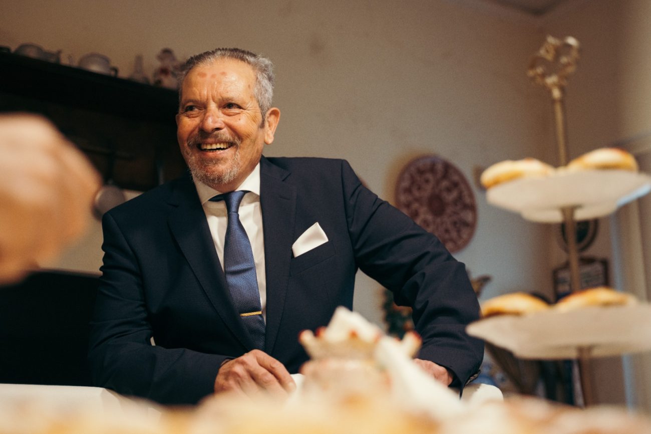 Carmelo Chittari sorridente in giacca e cravatta, ritratto intimo che racconta una vita dedicata alla cura degli altri, tra umanità, professionalità e valori familiari profondi.