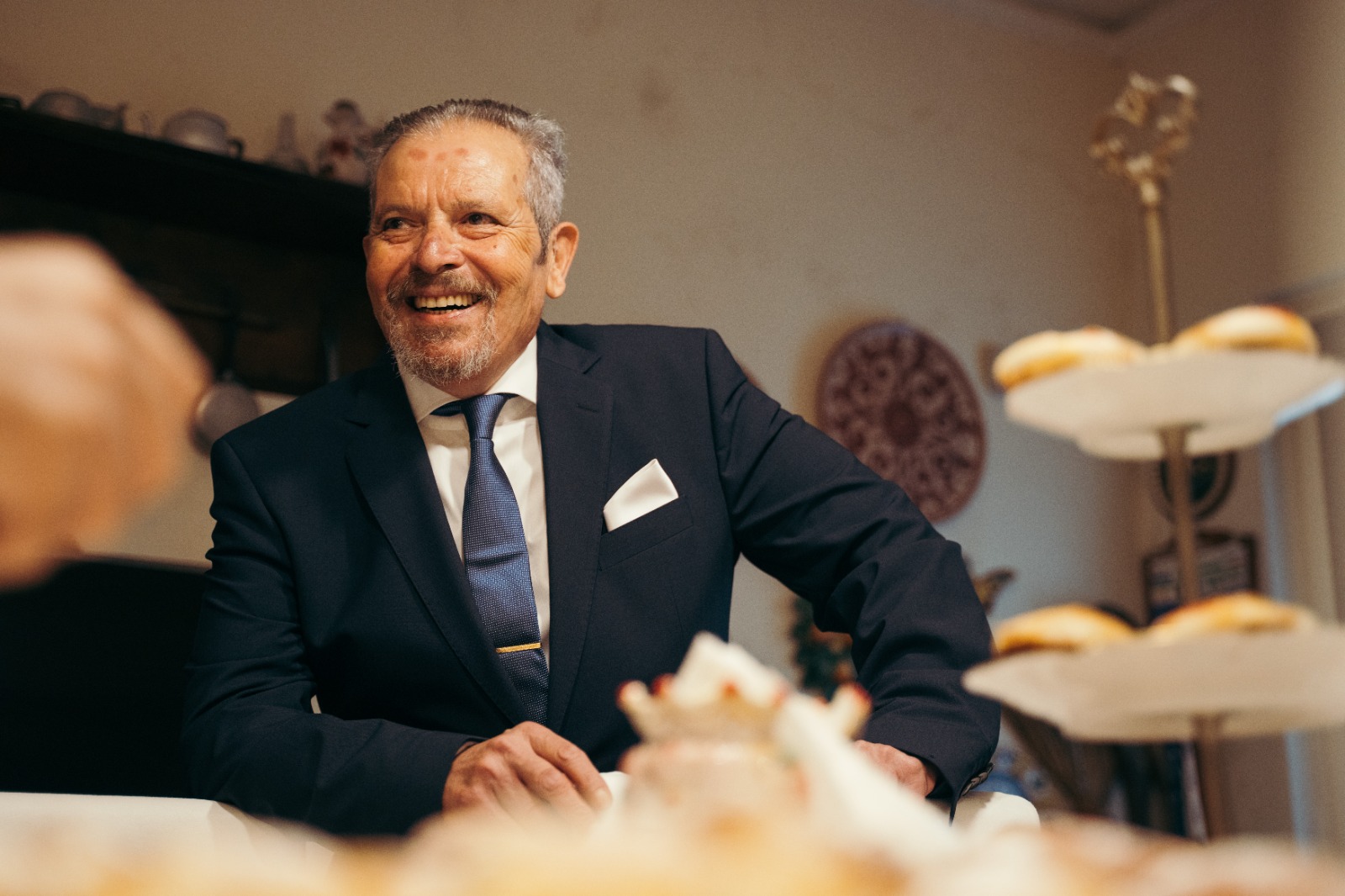 Carmelo Chittari sorridente in giacca e cravatta, ritratto intimo che racconta una vita dedicata alla cura degli altri, tra umanità, professionalità e valori familiari profondi.