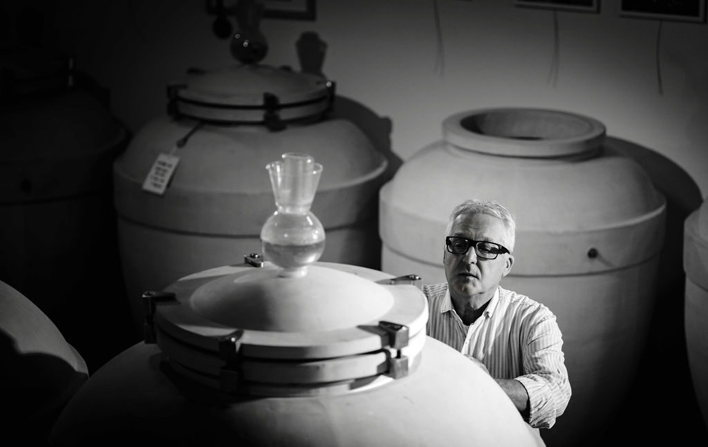 Silvio Jermann nella cantina di Sylvmann in Cuèj tra le anfore di vinificazione, immagine in bianco e nero